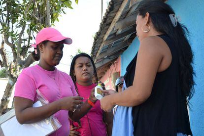 Una trabajadora proporciona repelente y preservativos a varias mujeres en Barranquilla, Colombia, en la campaña contra el zika.