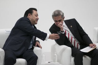 Héctor Serrano, secretario de Gobierno, muestra su teléfono al jefe de Gobierno Miguel Ángel Mancera, en enero de 2014.