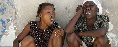 Dos mujeres lloran tras el episodio sangriento en una barriada de Puerto Príncipe.