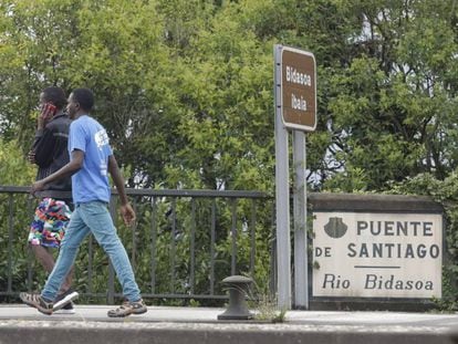 Dos migrantes intentan este jueves cruzar el puente sobre el río Bidasoa que separa España de Francia.