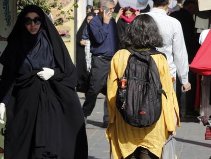 Una adolescente pasa sin velo junto a una mujer ataviada con el chador en Teherán, el 13 de septiembre.