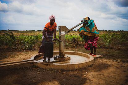 Dos vecinas de Calanga extraen agua de una fuente con la tranquilidad de que beberán sin riesgo de contraer una enfermedad de transmisión hídrica.