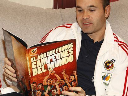 Iniesta lee el cómic 'El año que fuimos campeones del mundo'.