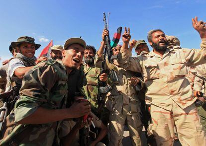 Combatientes celebran la caída de Gadafi, el último enclave importante en manos de las tropas del dictador.