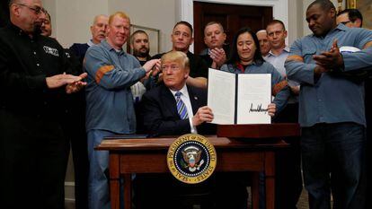 Trump firma los aranceles rodeado de trabajadores del acero y el aluminio.