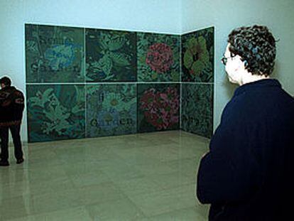 Dos visitantes de la exposición del Palacio Episcopal de Málaga, junto a una obra.