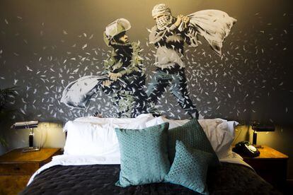 Una pintura de Banksy muestra a un policía israelí de la frontera y a un palestino en una lucha de almohadas, en una de las habitaciones del hotel "Walled Off" en la ciudad cisjordana de Belén.