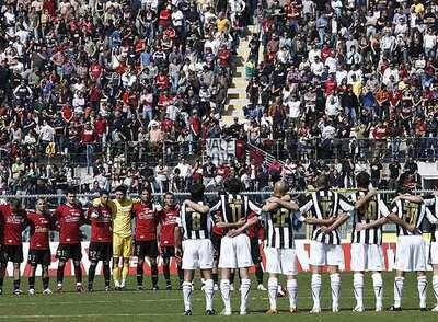 Los jugadores del Siena y el Livorno, durante el minuto de silencio guardado en los estadios italianos.