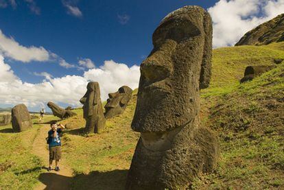 Un turista hace fotos de un busto gigante en las laderas del volcán Rano Raraku en la isla de Pascua (Chile).