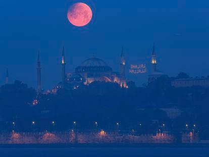 A full moon rises above the iconic Haghia Sophia in Istanbul, Turkey, early Monday, May 16, 2022. (AP Photo/Mucahid Yapici)