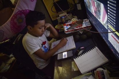 Un niño toma clases a distancia en un negocio de verduras de la Central de Abastos el 4 de septiembre de 2020 en Ciudad de México.