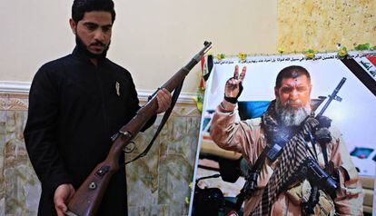 El hijo de Ali Jayad al Salhi, héroe entre los milicianos chiíes, posa en Basora junto a una foto de su padre, muerto en combate contra el ISIS.