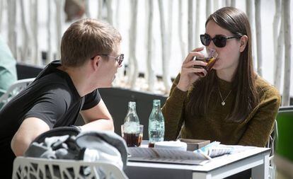 Dos joves prenen uns refrescos en una terrassa a Barcelona.