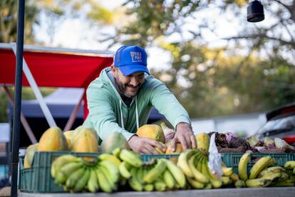 Bryan Didier atiende a sus clientes en su puesto de productos agrícolas en la Feria Verde de Aranjuez, en San José, Costa Rica.