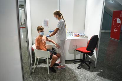 Una sanitaria vacuna con la primera dosis de Moderna a un adolescente, el pasado agosto en Valencia.