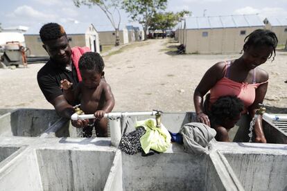 Dos mujeres haitianas migrantes bañan a sus bebés en el centro de acogida de San Vicente, en la provincia de Darien, en Panamá, el 9 de febrero de 2021. Panamá está admitiendo a miles de migrantes que no pueden acceder a Costa Rica por las restricciones de la pandemia. Entre las causas por las que miles de niños haitianos cruzan la frontera de su país, la menos mala es que vayan acompañando a sus familiares.
