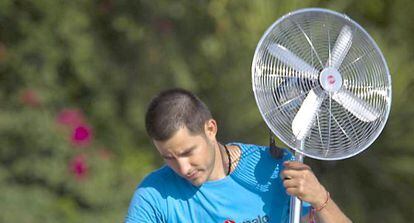 Un hombre transporta un ventilador en Sevilla.