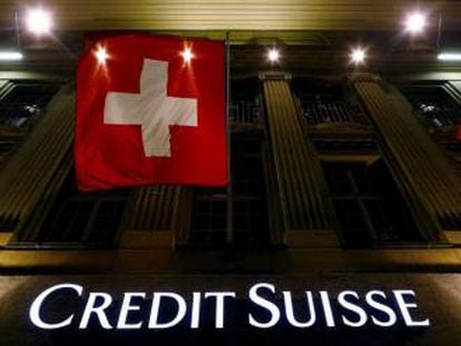Logo de Credit Suisse bajo la bandera nacional suiza, en Berna (Suiza).