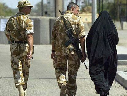 Una mujer musulmana conversa con dos soldados británicos en una calle de Basora, al sur de Irak.