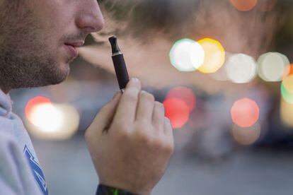 Un hombre fuma un cigarrillo electr&oacute;nico en una calle de Barcelona.