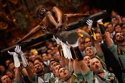 Los legionarios levantan en Cristo de Mena en Málaga, durante la procesión del Jueves Santo.