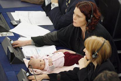 La europarlamentaria danesa Hanne Dahl vota en una sesión con su bebé al lado.