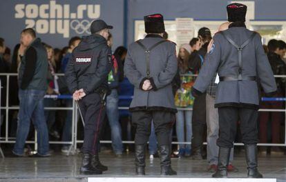 Un par de cosacos y un polic&iacute;a rusos patrullan por el aeropuerto Adler de Sochi (Rusia)