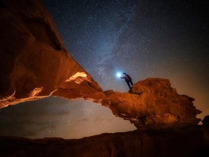 Noche estrellada en un arco de piedra del desierto de Wadi Rum, en Jordania.