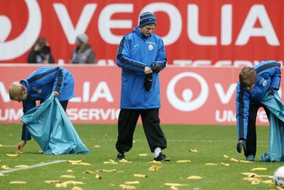 Recogepelotas del Rostock limpian el campo de las banadas lanzadas por los seguidores del equipo.