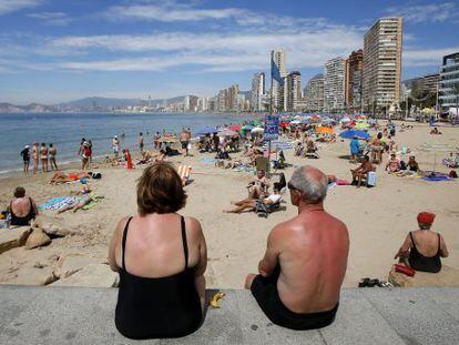 Una pareja de jubilados disfrutan del sol y las altas temperaturas en la playa de Levante en Benidorm, en Alicante. 