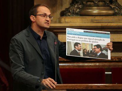 El presidente de ICV-EUIA, Joan Herrera, muestra un recorte del diario EL PAÍS con declaraciones del presidente de la Generalitat, Artur Mas.