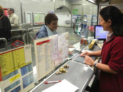 Una taquillera atiende a una pasajera del Metro de Madrid.