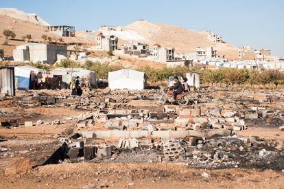 Refugiados sirios recorren los restos de un campamento quemado durante una redada del Ejército libanés en febrero de 2014