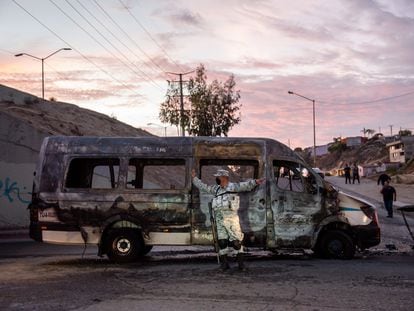 Un elemento de la Guardia Nacional resguarda la zona donde un grupo delictivo incendió un vehículo, en Tijuana, Estado de Baja California, el 12 de agosto de 2022.
