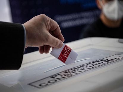 Un miembro del Servicio Electoral muestra cómo emitir su voto en un colegio electoral antes del referéndum en Santiago, Chile.