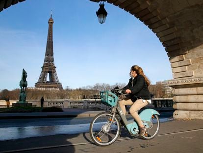 Una mujer se mueve con una bicicleta pública de París.
