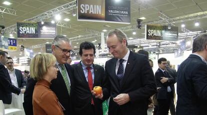 Alberto Fabra, con un caqui en la mano, en la feria Fruit Logistica de Berl&iacute;n.