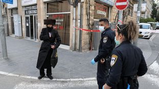 Dos agentes identifican a un ultraortodoxo en un acceso al barrio de Mea Shearim, el domingo en Jerusalén.