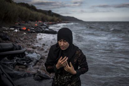 Una mujer sale del mar tras llegar en bote a la isla griega de Lesbos.