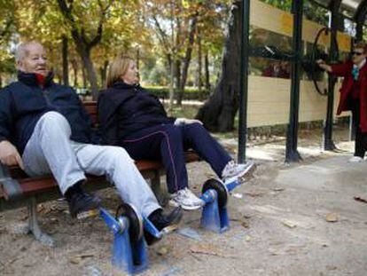Unos jubilados hacen ejercicio en un parque.