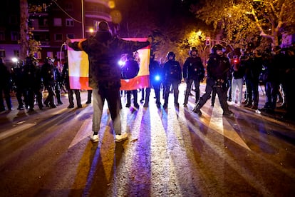 Un manifestante se enfrenta a la policía con una bandera de España, en la que se ha recortado el escudo.