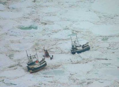 Un helicóptero de los equipos de rescate sobrevuela dos de los barcos atrapados por el hielo en Canadá.