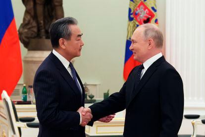 El presidente ruso, Vladímir Putin, y el máximo representante diplomático de China, Wang Yi, estrechan las manos en su encuentro en Moscú de este miércoles.