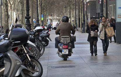 Un motociclista circula por la acera de la Diagonal de Barcelona. 