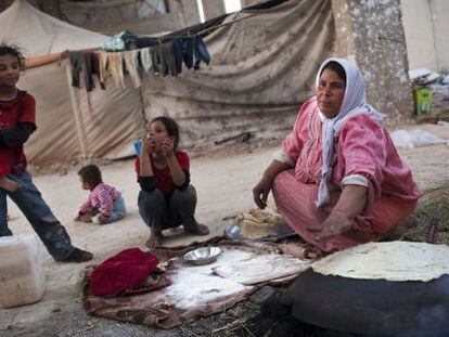 Una mujer cocina pan cerca de la ciudad de Alepo.