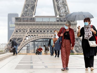 Varias personas, frente a la torre Eiffel, una de las grandes atracciones turísticas de París.