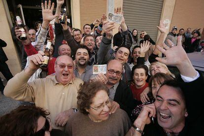 Algunos vecinos de Castellón celebran su buena suerte mostrando el décimo del Niño con el número 87657.