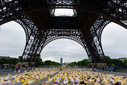 Cientos de personas hacen yoga en París, este domingo.