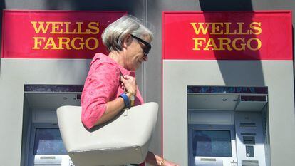 Una mujer pasa delante de dos cajeros automáticos de Wells Fargo en Pasadena (California), en una imagen de archivo.