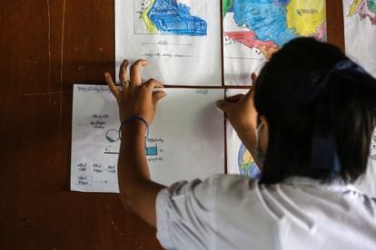 Aye Aye Than pega una tarea de ciencias en la pared de su clase en un Centro de Aprendizaje para Migrantes en Mae Sot, Tailandia, donde vive refugiada tras el golpe de Estado militar en su país, Myanmar. "Antes de mudarme a Tailandia, quería ir a la universidad". Ahora quiere ser profesora.